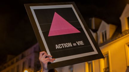 Une affiche de l'association Act Up-Paris lors d'une manifestation le 1er janvier 2021 à Paris, à l'occasion de la Journée mondiale de lutte contre le sida. (SOPHIE LIBERMANN / HANS LUCAS / AFP)