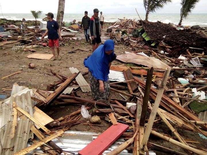 Des résidents de Carita (Indonésie) inspectent les débris sur la plage après le tsunami, le 23 décembre 2018. (SEMI / AFP)