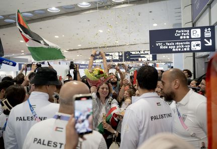 Un comité d'accueil attend les athlètes palestiniens à l'aéroport de Paris Charles de Gaulle, le 25 juillet 2024. (BENJAMIN BERAUD / HANS LUCAS via AFP)