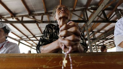 Une femme prie dans une &eacute;glise de Tacloban (Philippines), le 5 d&eacute;cembre 2014. (MAXPPP)