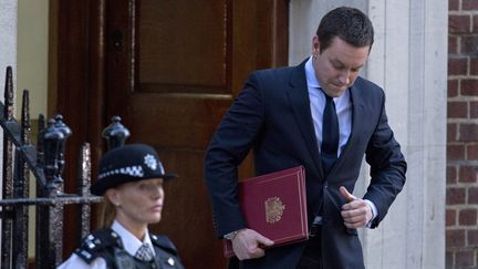 L'attach&eacute; de presse de la famille royale sort de la maternit&eacute; de l'h&ocirc;pital St Mary's &agrave; Londres charg&eacute; d'une missive pour Buckingham Palace, le 22 juillet 2013.&nbsp; (JUSTIN TALLIS / AFP)