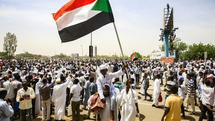 Un garçon soudanais brandit le drapeau national après que le président Omar el-Béchir a été démis. Khartoum, la capitale du Soudan, le 12 avril 2019.&nbsp; (AFP/EBRAHIM HAMID)