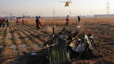 Des équipes de secouristes du Croissant-Rouge iranien fouillent un terrain vague parmi des débris éparpillés après le crash d'un Boeing d'une compagnie ukrainienne, le 8 janvier 2020, près de Téhéran. (IRANIAN RED CRESCENT SOCIETY / AFP)