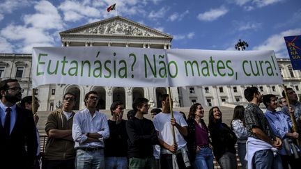 Des opposants à l'euthanasie portent une pancarte "Euthanasie ? Ne tuez pas, soignez !", jeudi 20 février 2020 devant l'Assemblée nationale à Lisbonne (Portugal). (PATRICIA DE MELO MOREIRA / AFP)