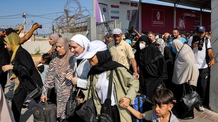 Des personnes franchissent une porte d'accès au terminal de Rafah, à la frontière entre la bande de Gaza et l'Egypte, le 1er novembre 2023. (MOHAMMED ABED / AFP)