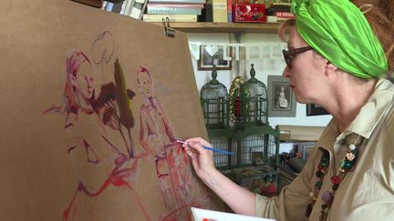 Nathalie Novi, l'initiatrice du projet de fresque collective, en train de peindre sa "famille confinée",&nbsp;dans son atelier du Jura.&nbsp; (H. Perret / France Télévisions)