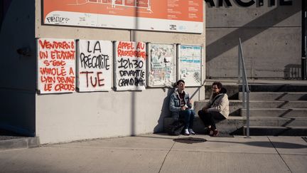 Deux étudiants à l'université Jean-Jaurès à Toulouse (Haute-Garonne), le 12 novembre 2019, devant une banderole portant le slogan "La précarité tue". (LILIAN CAZABET / HANS LUCAS / AFP)