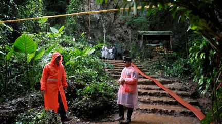 Des secouristes attendent, le 28 juin 2018, devant l'entrée de la grotte&nbsp;Tham Luang (Thaïlande),&nbsp;où des enfants et leur entraîneur sont bloqués. (SOE ZEYA TUN / REUTERS)