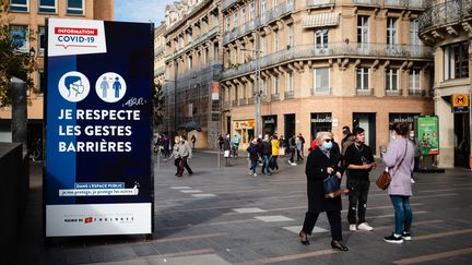 Des personnes marchent dans une rue de Toulouse (Haute-Garonne), mardi 13 octobre 2020.&nbsp; (LILIAN CAZABET / HANS LUCAS / AFP)