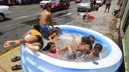 Pendant que la neige tombe sur l'Europe, des enfants tentent de se rafra&icirc;chir dans une piscine gonflable &agrave; Lima (P&eacute;rou), le 5 f&eacute;vrier 2012. (ENRIQUE CASTRO-MENDIVIL / REUTERS)