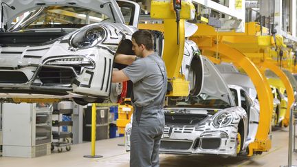 Un salari&eacute; travaille sur&nbsp;une cha&icirc;ne d'assemblage de Porsche, &agrave; Stuttgart (Allemagne), le 11 mars 2014. (THOMAS KIENZLE / AFP)