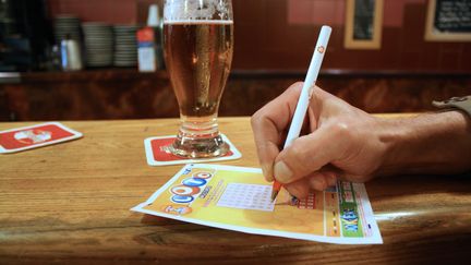 Une personne joue au Loto le 12 juillet 2012 &agrave; Paris. (ANA AREVALO / AFP)