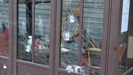 Des impacts de balles sur une vitre du bar La Belle Equipe, au lendemain des attentats, le 14 novembre 2015, à Paris. (DURSUN AYDEMIR / ANADOLU AGENCY / AFP)