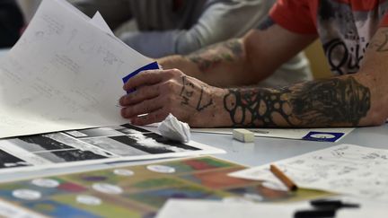 Un atelier BD en prison : des détenus créent des pages de bande dessinée pour le concours Transmurailles dans le cadre du Festival de la BD d'Angoulême.
 (GEORGES GOBET / AFP)