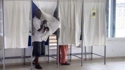 Un homme sort de l'isoloir, à Cayenne (Guyanne). Janvier 2010. (JEROME VALLETTE / AFP)