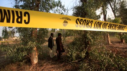 Deux hommes&nbsp;dans la zone où l'adolescent a été dévoré par les lions, le 26 février 2020, à Lahore (Pakistan).&nbsp; (MOHSIN RAZA / AFP)