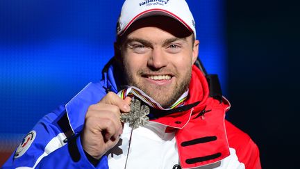 Le skieur français&nbsp;David Poisson&nbsp;montre sa médaille de bronze aux championnats du monde de&nbsp;Schladming (Autriche), le 9 février 2013. (OLIVIER MORIN / AFP)