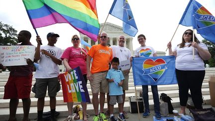 Devant la Cour Supr&ecirc;me, les partisans du mariage homosexuel brandissent des drapeaux arc-en-ciel et des appels &agrave; "voter pour l'amour". Avec, omnipr&eacute;sent, le drapeau de l'Union am&eacute;ricaine pour les libert&eacute;s civiles (ACLU), qui a souvent fait &eacute;voluer la Constitution am&eacute;ricaine, comme cela a &eacute;t&eacute; le cas vendredi 26 juin avec la l&eacute;galisation du mariage gay partout sur le territoire am&eacute;ricain. (ALEX WONG / GETTY IMAGES NORTH AMERICA/AFP)