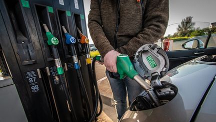 Un homme fait le plein de sa voiture en essence sans plomb 98 dans une station service, le 24 mars 2022 (illustration). (XAVIER LEOTY / MAXPPP)