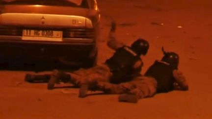 Des officiers de sécurité burkinabés couchés au sol pendant la prise d'otages à l'hôtel Splendid, à Ouagadougou, vendredi 15&nbsp;janvier.&nbsp; (REUTERS)