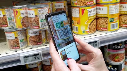 Un consommateur utilise l'application Yuka dans un supermarché de Valence (Drôme), le 11 novembre 2019. (NICOLAS GUYONNET / HANS LUCAS / AFP)