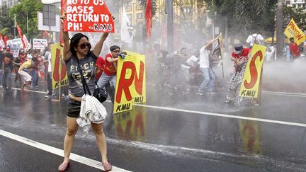 Des manifestants anti-am&eacute;ricains sont asperg&eacute;s avec des canons &agrave; eau lors d'affrontements avec la police pr&egrave;s de l'ambassade des Etats-Unis &agrave; Manille (Philippines), le 25 f&eacute;vrier 2014. (ROMEO RANOCO / REUTERS)