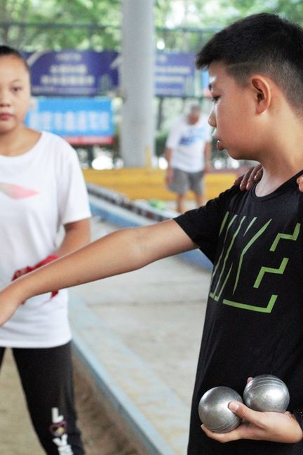 Wang Yusha, un élève de la Qi Bin Middle School, joue aux boules avec des amis. (RAPHAËL GUILLET)