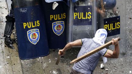 Un homme s'en prend aux forces de l'ordre lors d'une op&eacute;ration d'&eacute;vacuation d'un bidonville &agrave; Makati (Philippines), le 24 septembre 2012. (BULLIT MARQUEZ / AP / SIPA)