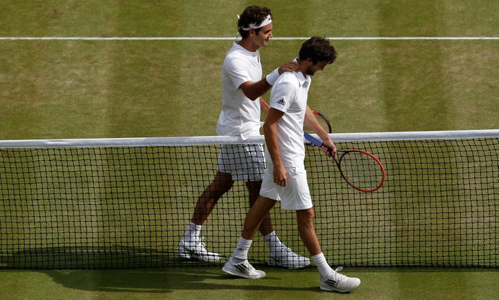 Gilles Simon et Roger Federer lors du quart de finale de Wimbledon remporté par le Suisse, le 8 juillet 2015 sur le gazon britannique. (ADRIAN DENNIS / AFP)