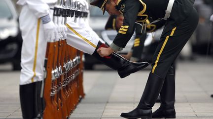 Les membres de la garde d'honneur cirent leurs bottes avant la c&eacute;r&eacute;monie de bienvenue organis&eacute;e pour la visite du pr&eacute;sident portugais&nbsp;Anibal Cavaco Silva &agrave; P&eacute;kin (Chine), le 15 mai 2014. (KIM KYUNG-HOON / REUTERS)