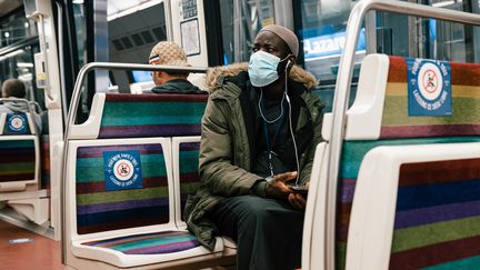 Un homme muni d'un masque dans le métro parisien, dont certains sièges sont condamnés par des stickers en raison de l'épidémie de coronavirus, le 9 mai 2020. (KARINE PIERRE / HANS LUCAS / AFP)