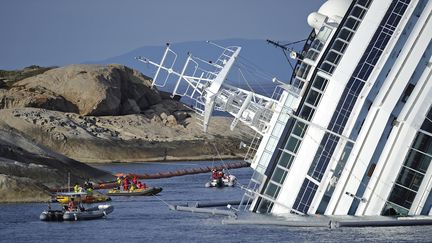 Des techniciens travaillent sur l'&eacute;pave du "Concordia", le 26 janvier 2012, sur la c&ocirc;te de l'&icirc;le italienne du Giglio. (FILIPPO MONTEFORTE / AFP)