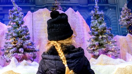 Une enfant devant une vitrine de Noël animée du grand magasin Le Bon Marché à Paris. (BRUNO LEVESQUE / MAXPPP)