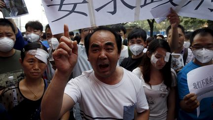 Des habitants de Tianjin manifestent, le 17 ao&ucirc;t 2015, en marge d'une conf&eacute;rence de presse des autorit&eacute;s municipales. (KIM KYUNG HOON / REUTERS)