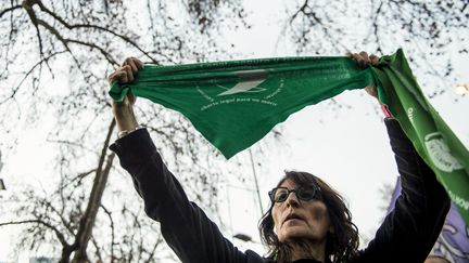 Une femme manifestant pour le droit à l'avortement en Argentine porte un foulard vert, symbole de la lutte pour ce droit, lors d'un rassemblement devant l'ambassade de l'Argentine au Chili, le 8 août 2018.&nbsp; (MARTIN BERNETTI / AFP)