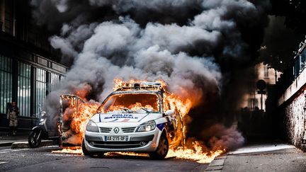 Une voiture de police en flammes à Paris, le 18 mai 2016, en marge&nbsp;d'un rassemblement de policiers à l'appel de leurs syndicats contre la "haine anti-flics". (SIMON GUILLEMIN / HANS LUCAS / AFP)