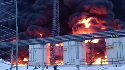 An image taken from a video released by the Russian Emergencies Ministry on January 19, 2024 shows rescuers working to put out a fire at an oil depot following a drone attack in Klintsy, Bryansk Region (Russia).  (Russian Ministry of Emergencies / AFP)