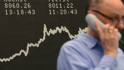 Un trader&nbsp;au t&eacute;l&eacute;phone &agrave; la Bourse de Francfort (Allemagne), le 14 mars 2013. (ARNE DEDERT / DPA)