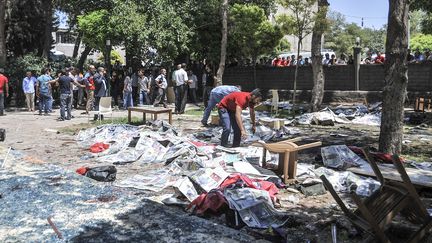 Les corps des victimes ont &eacute;t&eacute; recouverts de journaux apr&egrave;s l'explosion qui a eu lieu dans le jardin d'un centre culturel de Suru&ccedil; (Turquie), le 20 juillet 2015.&nbsp; (RAUF MALTAS / ANADOLU AGENCY / AFP)