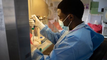 Un technicien de laboratoire manipule des prélèvements sanguins pour un test de dépistage du coronavirus à Kigali (Rwanda), le 11 juillet 2020. (SIMON WOHLFAHRT / AFP)