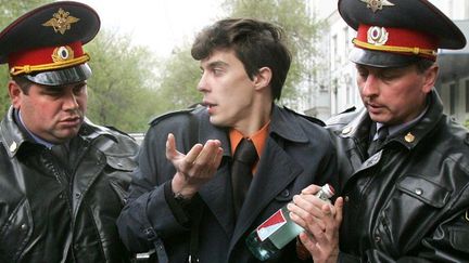 Deux policiers russes arrêtent le leader d'une séance de dégustation d'eau minérale géorgienne devant le siège de Rospotrebnadzor, à Moscou en 2006. La manifestation était organisée en réponse à l'embargo politique imposé par l'agence sanitaire contre la Géorgie et la Moldavie. (DENIS SINYAKOV / AFP)