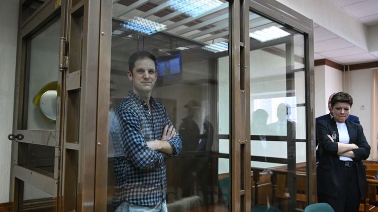 Evan Gershkovich stands in the defendants' box before the hearing to consider his appeal request, April 18, 2023. (NATALIA KOLESNIKOVA / AFP)