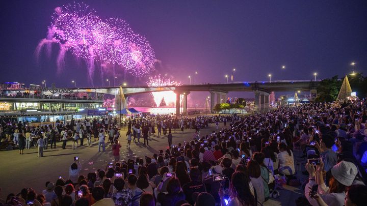 Le public regarde le feu d'artifice en clôture des célébrations pour les dix ans du groupe BTS, le 17 juin 2023, à Séoul (Corée du Sud). (ANTHONY WALLACE / AFP)