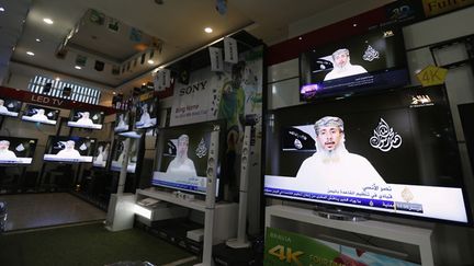 &nbsp; (Al-Qaïda au Yémen a revendiqué mercredi 14 janvier dans une vidéo, retransmise ci-contre sur les télévisions d’un magasin de Sanna, l'attaque contre Charlie Hebdo © REUTERS/Khaled Abdullah)