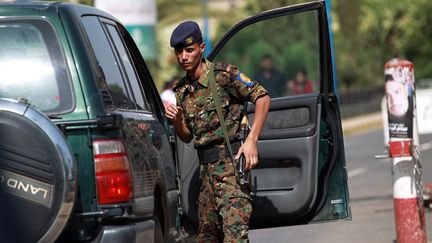 Un militaire inspecte des v&eacute;hicules &agrave; l'entr&eacute;e de l'a&eacute;roport de Sanaa (Y&eacute;men), le 7 ao&ucirc;t 2013. (MOHAMMED HUWAIS / AFP)