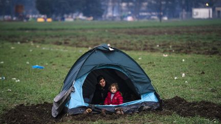 Une mère et son enfant vivent&nbsp;dans une tente en attendant que la frontière avec la Macédoine ouvre de nouveau. (DIMITAR DILKOFF / AFP)