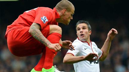 Le Mancunien Robin Van Persie (en blanc) surpris par le défenseur de Liverpool Martin Skrtel