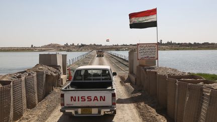 Des soldats irakiens franchissent un pont provisoire au-dessus du Tigre, le 4 septembre 2016. (YUNUS KELES / ANADOLU AGENCY / AFP)