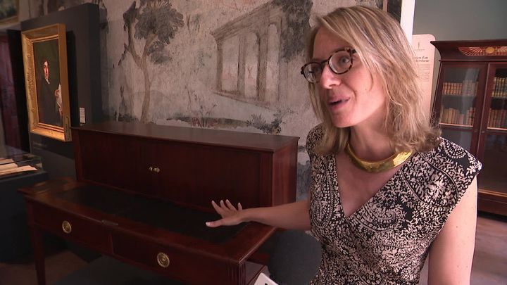 Caroline Dugand, Conservatrice du Musée Champollion devant le bureau en acajou de Jean-François Champollion. (D. Semet. / France Télévisions)