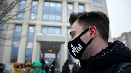 Un soutien de Mémorial porte un masque où figure le logo de l'ONG devant le tribunal de Moscou (Russie), le 29 décembre 2021. (ALEXANDER NEMENOV / AFP)